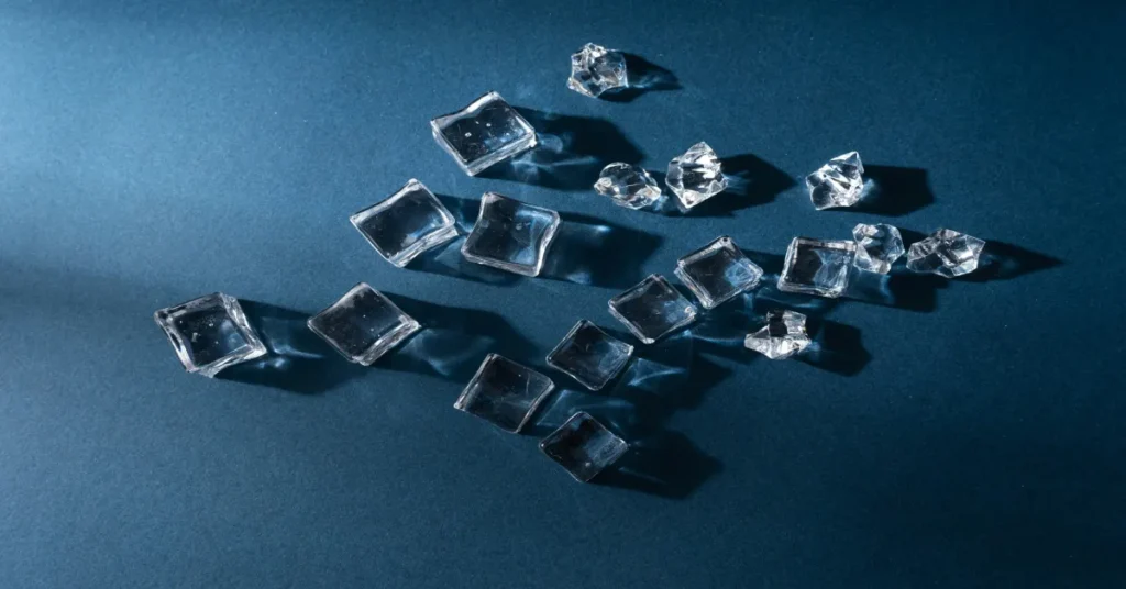 Clear square ice cubes scattered on a blue background, representing fresh ice from the best countertop nugget ice maker with dispenser.