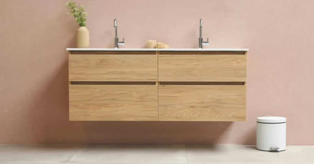 Small white mini trash can with lid standing next to a floating wooden vanity in a modern bathroom setup